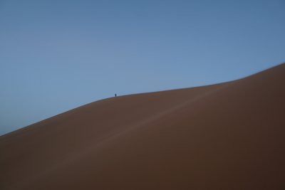 サハラ砂漠の砂丘をあるく人